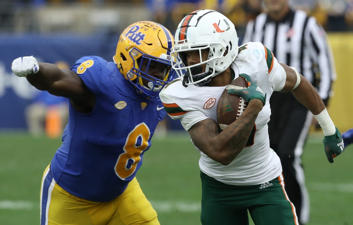 Oct 30, 2021; Pittsburgh, Pennsylvania, USA; Miami Hurricanes running back Jaylan Knighton (4) runs against Pittsburgh Panthers defensive lineman Calijah Kancey (8) after a catch during the fourth quarter at Heinz Field. Miami won 38-34. Mandatory Credit: Charles LeClaire-USA TODAY Sports